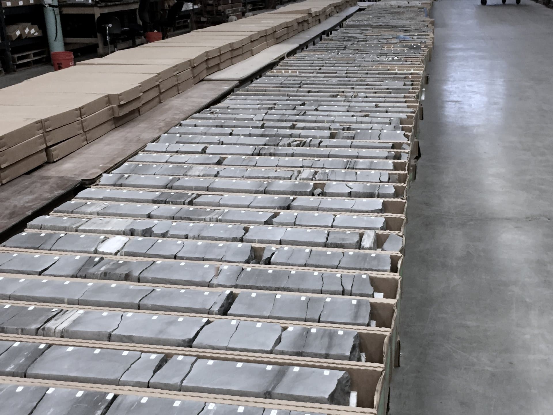 Rows of rock core samples laid out in trays in a core warehouse